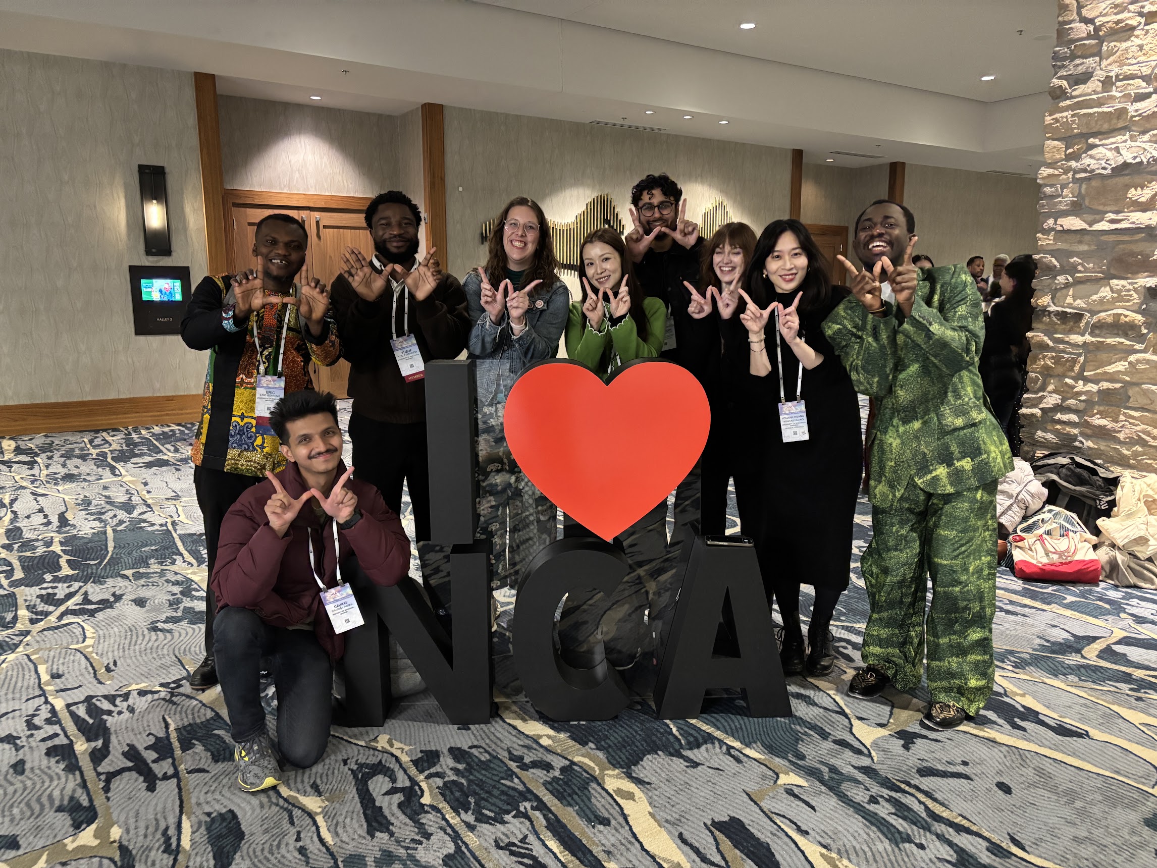 UW-Madison RPC graduate students posing behind NCA logo at NCA 2025