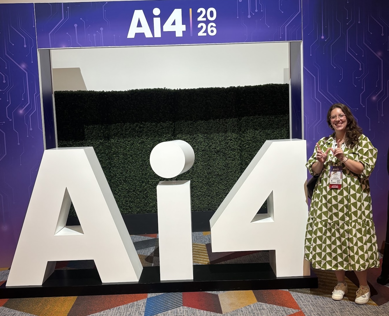Sara posing in front of the Ai4 sign at the conference, 2026